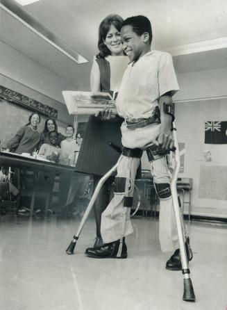 Carlyle Husbands, 13, who can walk, thanks to the skill of a Toronto doctor, smiles with teacher Janice Sinclair