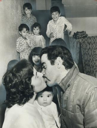 Off to a new job, Antonio Furtado kisses his wife goodby as six of their nine children look on