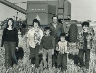 Farmer Paul Lemauviel stands in a wheat field with his family near Duck Lake, Sask