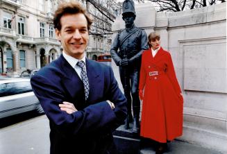 Scottish-born designer Alistair Blair with model wearing his full-skirted, double-breasted coat in rich red cashmere