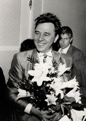 Soviet star: Above, designer Viyacheslav Zaitsev, dressed in an emerald green jacket and matching vest, clutches a bunch of lilies
