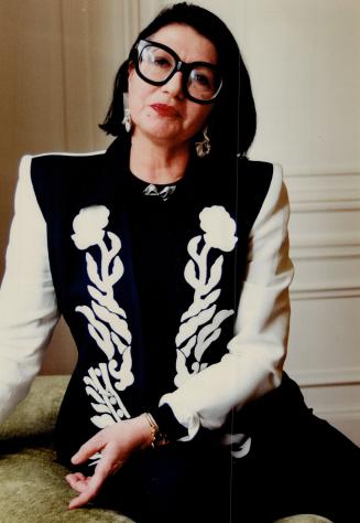 Emmanuelle Khanh in an appliqued suit from her spring line, wearing the famous glasses she created in 1971