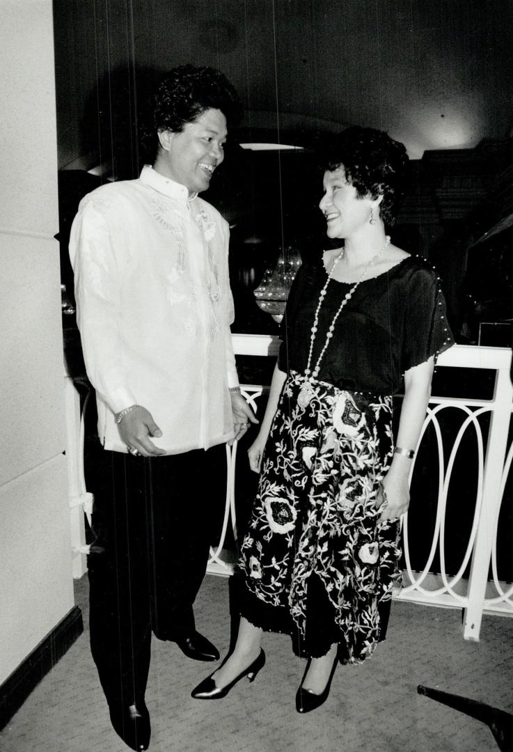 Hospital worker Verth Bugtong, wearing the traditional embroidered shirt called a barong, above, chats with Manila-based couturiere Patis Tesoro, who is wearing one of her own designs