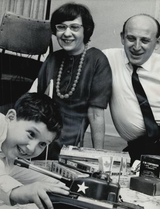 Father and Stepmother watch David Grunberg play with his Christmas toys