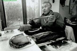 Keeper of the pipes: Farmer Martin Assinewe, 65, took the sacred native pipes to a church service marking the first anniversary of the ordination of the first Ojibwa priest