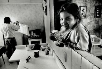 The Manitoba home of Kimberley Dorian, 5, left, is heated by a woodstove and has no indoor washroom