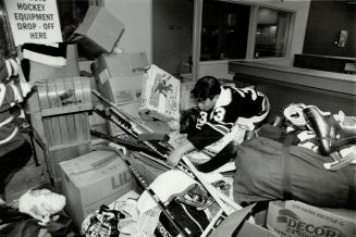 Alan Davies, MTHL Volunteer in Toronto Star Lobby with hockey equipment for Micmac Indians