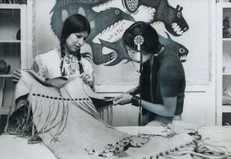 Ojibway Schoolgirls Mabel Mandomin (left), 21, in native costume, and Karen Lavallee, 18, work at their costume-making course in Native Indian Centre (...)