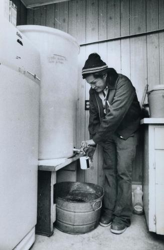 Indian Ed Scirvey in his Home pouring himself a glass of water, from tank of water, water that is delivered by truck