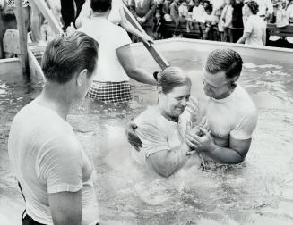 A Jehovah's Witness takes the plunge in mass baptism yesterday of 181 members of Christian sect at Woodbine Race Track