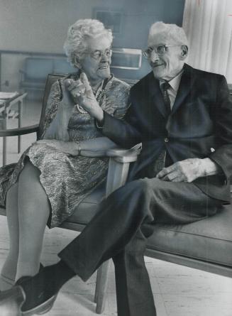 Celebrating his 105th Birthday, Simon Baverstock holds hand of 101-year-old Mrs