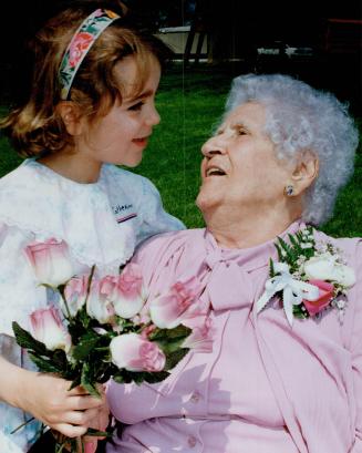 Catherine Aziz, 6, has roses for her grandmother Rose Aziz, who turns 100 today