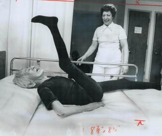 While nurse Lillian Richardson watches, 103-year-old Mary Theresa Cryer performs exercises