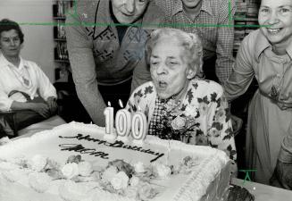 2nd century, Emma Louisa Lock, 100 years old today, blows out candles on her birthday cake at Cummer House home for the aged in North York at a party thrown for her yesterday by about 30 relatives