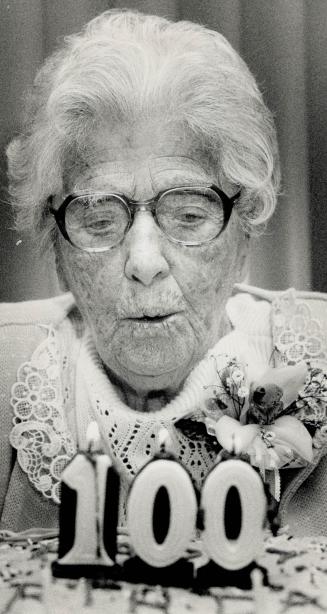 Celebrating a century, Esther Mawbey, a resident of the Ina Grafton Gage Home on O'Connor Drive, blows out the token candle on her 100th birthday cake yesterday