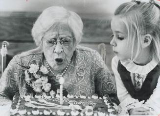 Blowing out the lone candle on her 100th-birthday cake, Annie Rumbles, a resident of Scarborough for 55 years, gets help from her great-granddaughter