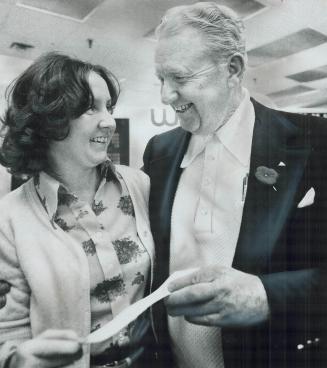 Holding $100,000 cheque, Joseph Tierney smiles at his daughter, Patricia, 25, at Wintario lottery office in Toronto today. Tierney, 62, a retired Bell(...)