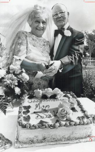 In her daughter's bridal veil, Becky Bach, 78, and her groom, Hyman, 88, cut the wedding cake yesterday at the Baycrest Centre for Geriatric Care. Bac(...)