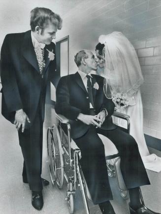 Father gets a kiss from the bride, Bridegroom John Gouzecky, 19, leans on wheelchair while his bride, Sharon Monnel, 17, kisses her father after weddi(...)