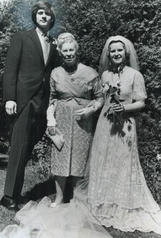 Mr. and Mrs. Brian Taylor with Mrs. B. L. Anderson, Mrs. Taylor wears wedding dress that belonged to grandmother