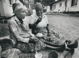 Irene Ngandu, 26, left, who has AIDS and is eight months pregnant, eats breakfast prepared by her mother, right, at Chikankata hospital