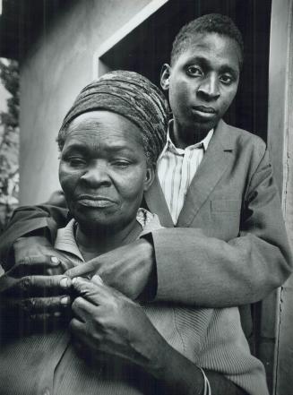 A sombre Gilbert Bowa, 29, embraces his mother the day after the two learned that he has an HIV infection