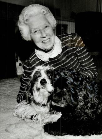With friends: Mary Patterson, who has worked at Toronto western Hospital since her graduation in 1934, relaxes at home with her cocker spaniels Gizzie, left, and Errin