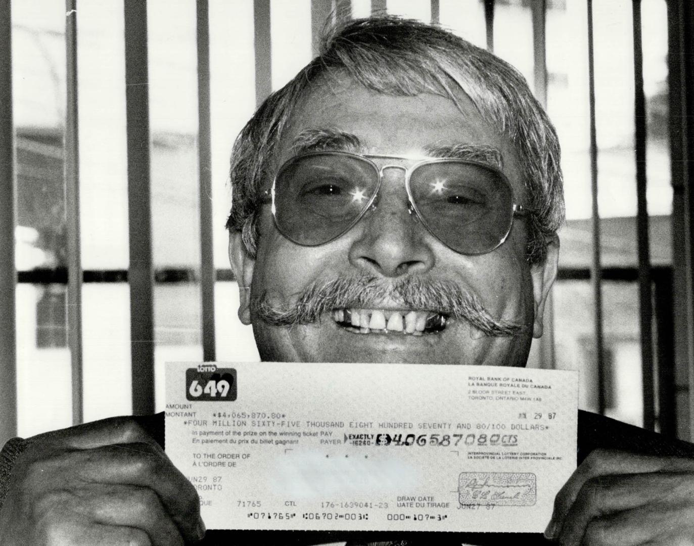 That's a $4 million smile, Michele Tullo, a 64-year-old Toronto janitorial contractor, shows off the cheque for $4,065,870 he picked up at the Ontario(...)