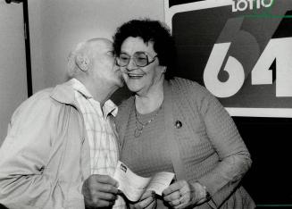 Couple wins $4 million, Ethel MacGregor gets a smooch from husband James as they hold a cheque for $4,051,977 they won in Saturday's Lotto 6/49 draw. (...)