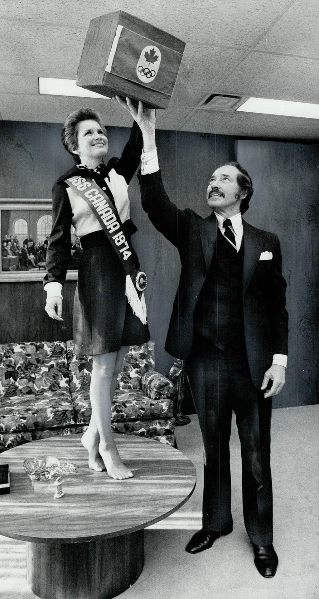 Picking lucky winners, Miss Canada, Blair Lancaster of Burlington, reaches  into box held by Olympic Trust president Walter Halder to pick winners of  O(...) – All Items – Digital Archive : Toronto Public Library