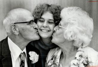 Anniversary Kiss, Robert McAuley Horner and wife Mary Jane give their youngest granddaughter, Vicky Bennett, 21, a sample of the kiss that kept them t(...)