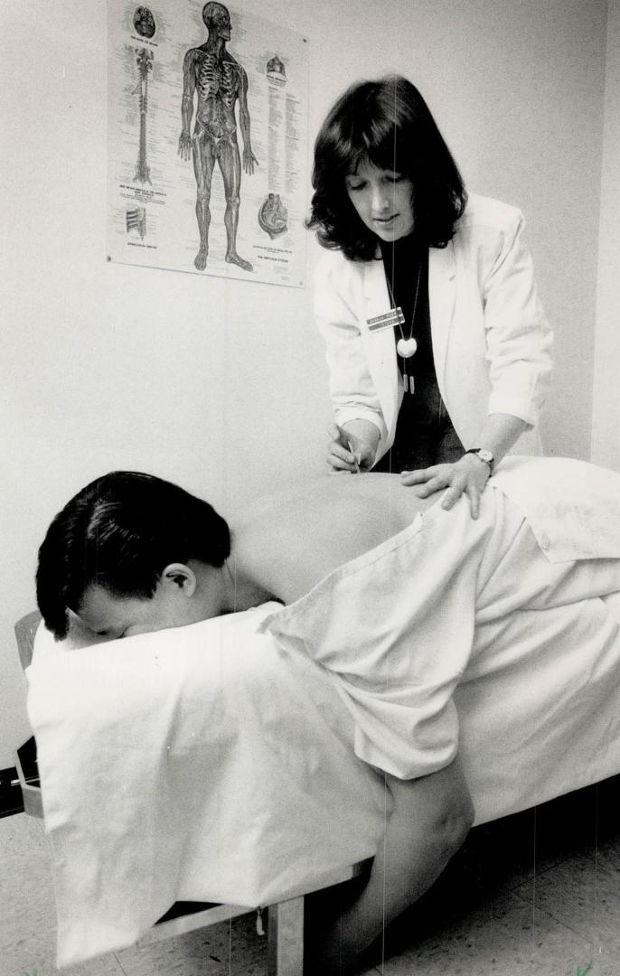 Future clouded: Naturopath students Michael Liebscher, left, and Angela Moore (performing acupuncture on David Wang) fear ability to practise will be curtailed