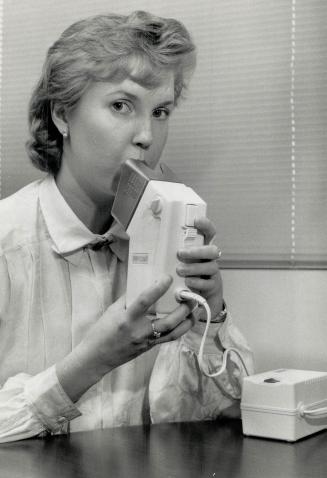 Clinical researcher Jeannette Koppenstenier demonstrates use of a nebulizer developed for a proposed study of the drug pentamidine. The nebulizer is not available to the general public