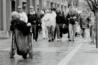Roll on: Scott MacArthur propels his wheelchair backward as he leads a group yesterday in Toronto raising money for AIDS research
