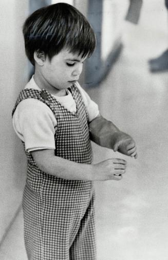 A miracle unfolds: Paul smidstrup, 3, takes a first look, in fascination and amazement, at his two hands after his artificial left arm had been fitted at the Ontario Crippled Children's Centre
