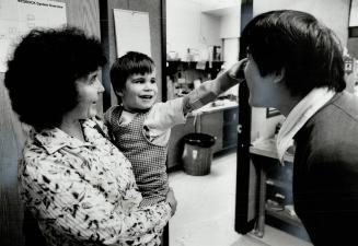 Grin of triumph: Paul delightedly tweaks the nose of technician Rinchen Dakpa with the artificial arm Dakpa fitted, while his equally delighted mother, Gail Smidstrup, holds him