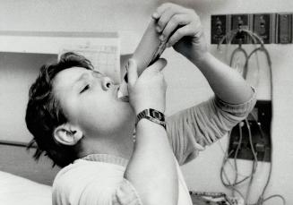 Measuring up: David Jolly, 13, suffers from asthma but now goes to the Ontario Crippled Children's Centre school where they teach him how to measure his condition, above, and control it