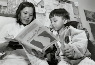 Parent-To-Be: Expectant mother Thi Dau Le shows pictures to 3-year-old Tran Kim Nhat at Regent Park pre-natal class