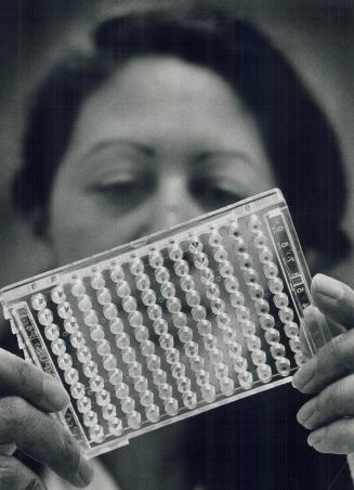 Top, technologist Sheila Robinson examines a tray of blood samples to confirm blood type and group