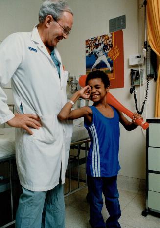 Happy boy: Domingo Montiero walks after surgery performed by Dr. Robert Salter, left. An infection at age 2 left his hips dislocated. before the operation, inset left, he had to crawl