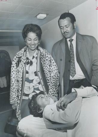 Debbie Heads Home, A Happy Girl, On a stretcher, in a body cast, 12-year-old Debbie Romney smiles at her mother and father, Mr. and Mrs. Cyril Romney,(...)