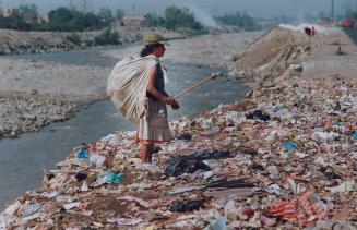 Cholera Peru - Along the banks of the Riu Rimac, which runs through Lima, a woman sifts through the garbage