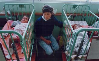 Cholera, Peru - A mother comforts her child (right) at Hospital De Apoyo aria Auxiliadora