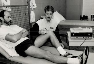 Tender care: Physiotherapist Robert Ray monitors Court Thomson's injured knee at the Mount Sinai sports medicine clinic