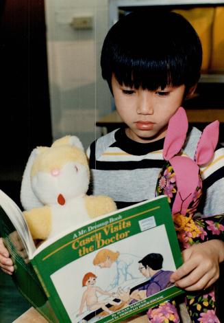. . .little boy Hiek Chau, 6, with two rabbit toys