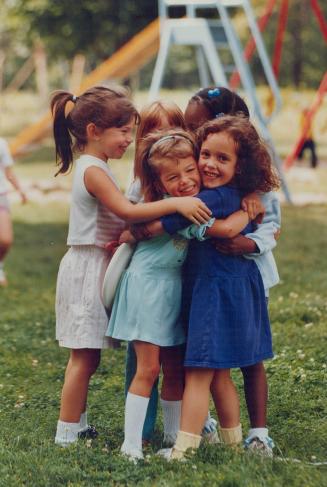 Friends rejoice: Happy Ashley Dyer, 4, right, who has cystic fibrosis, is hugged by friends at a playgound yesterday after news of research breakthrough