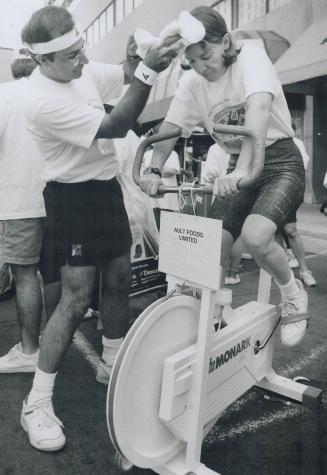 A really hot team, Massoud Poustchi cools off cyclist Carol Johnston as she pedals for a 10-minute stretch during the Delta/Perrier Drive for Diabetes(...)