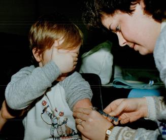 Aaron Robinson, 4, knows what's coming as nurse Sharon Connell administers a meningitis vaccination in Lindsay, Ont
