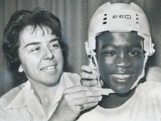 Merry christmas, Solomon Green, 11, of the Bahamas, tries on helmet after leaving hospital where he had operation to correct crossed eyes. Helping him(...)