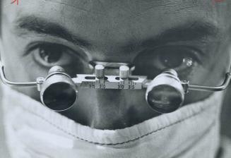 Magnifying spectacles were worn by surgeon during delicate transplant operation as he sliced away corneal tissue that was only tiny fractions of an in(...)